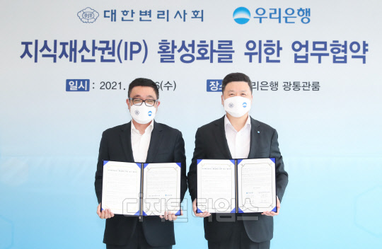 우리은행은 서울 중구 우리은행 본점에서 대한변리사회와 '지적재산권(IP) 활성화를 위한 업무협약'을 맺었다. 권광석(오른쪽) 우리은행장과 홍장원 대한변리사회 회장이 기념촬영을 하고 있다. (우리은행 제공)